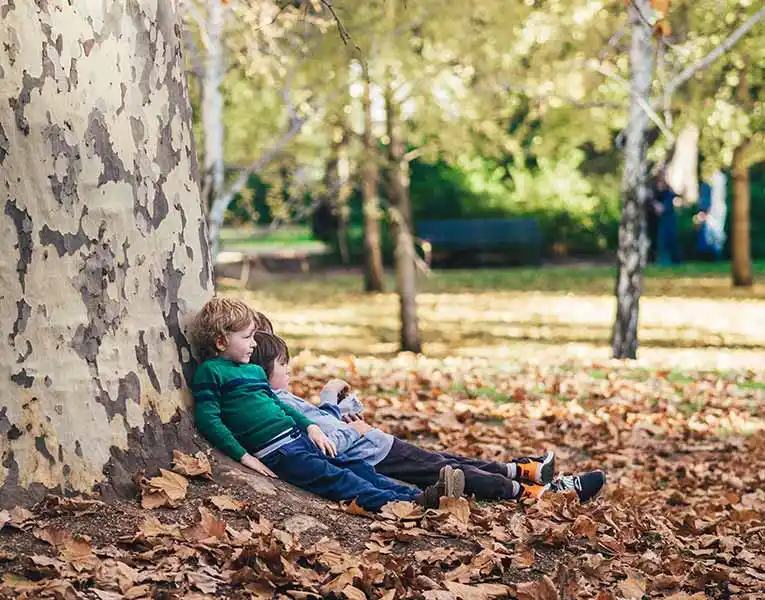 kids-lying-against-tree